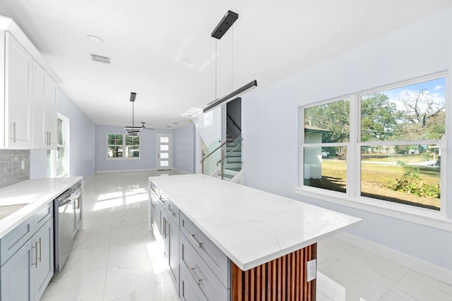 kitchen with gray cabinets, a kitchen island, hanging light fixtures, and white cabinets