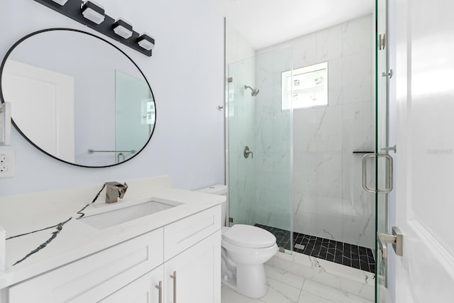 bathroom featuring vanity, a shower with shower door, and toilet