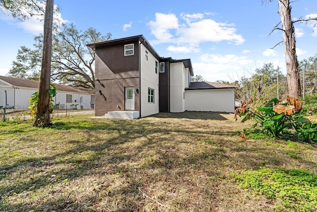 back of property featuring a lawn