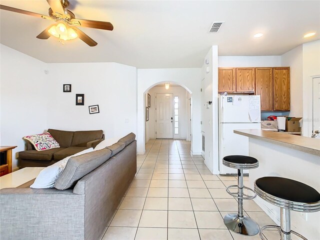 interior space featuring light tile patterned flooring, white fridge, and ceiling fan