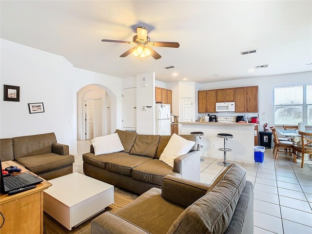 tiled living room with ceiling fan