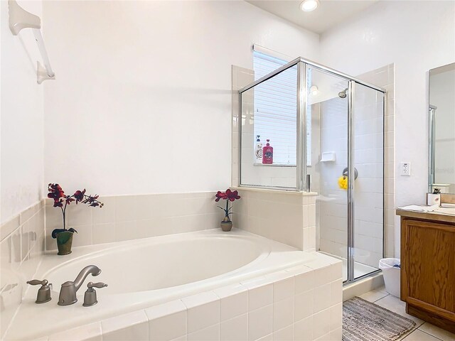 bathroom with independent shower and bath, vanity, a wealth of natural light, and tile patterned flooring