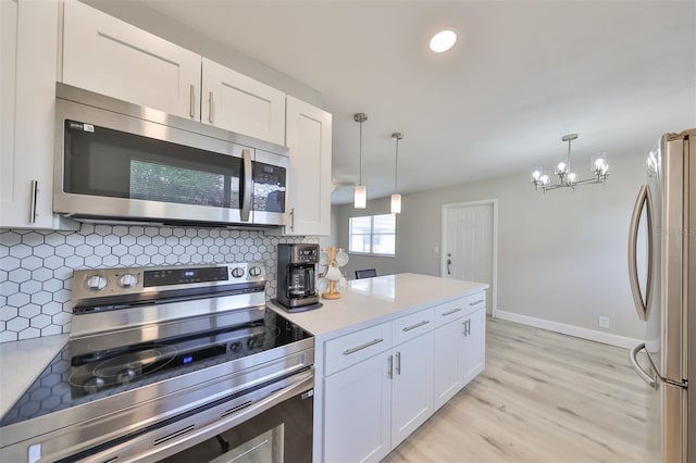 kitchen featuring white cabinets, pendant lighting, and stainless steel appliances