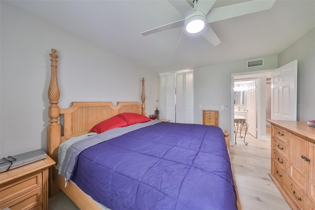 bedroom with ceiling fan, light wood-type flooring, and ensuite bath