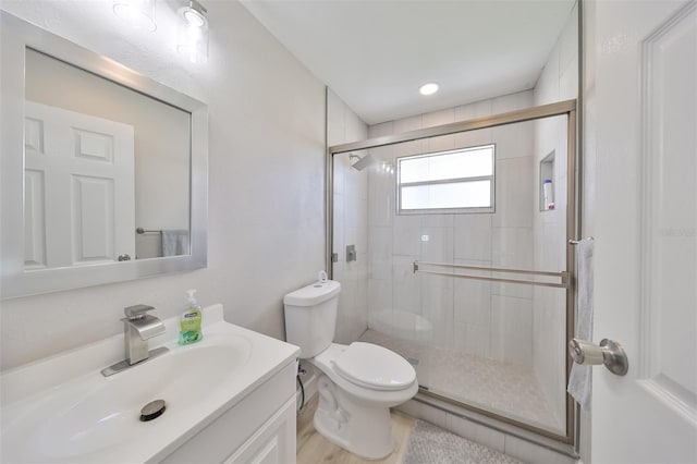 bathroom featuring hardwood / wood-style floors, vanity, toilet, and walk in shower