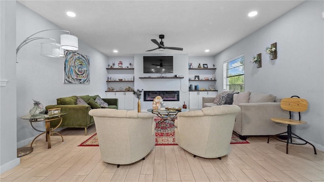 living room with light wood-type flooring and ceiling fan