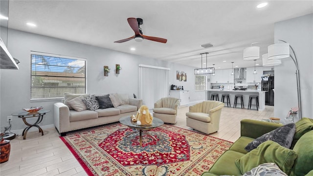 living room featuring ceiling fan and light hardwood / wood-style floors