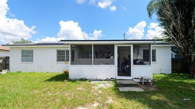 back of house with a sunroom and a yard