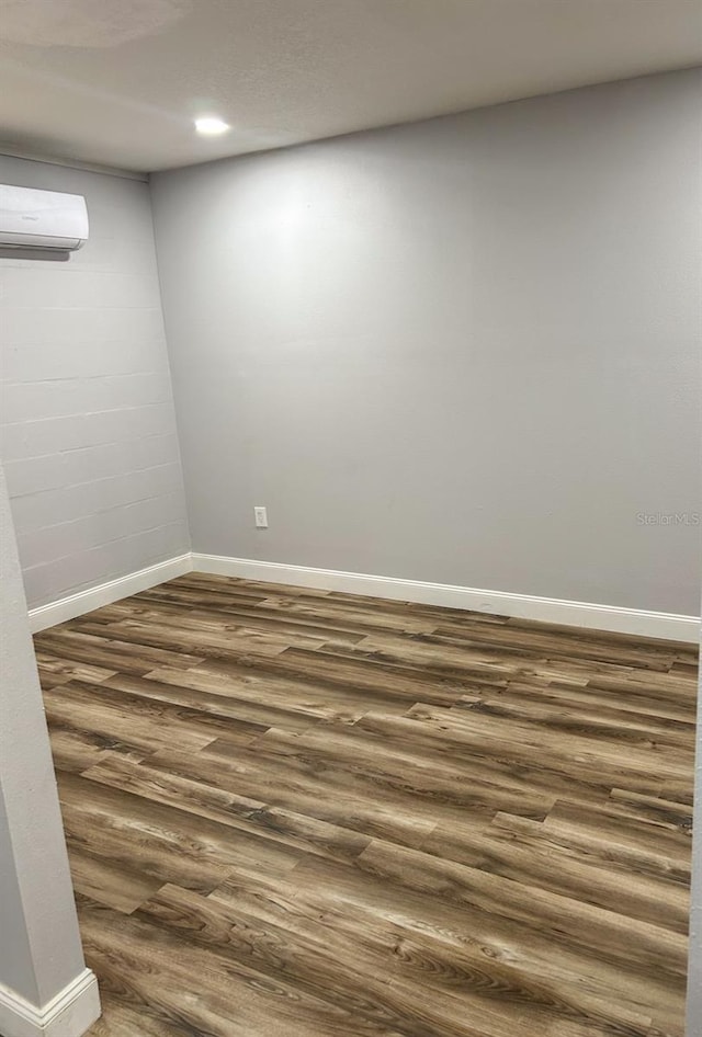 empty room featuring dark hardwood / wood-style floors and a wall mounted AC