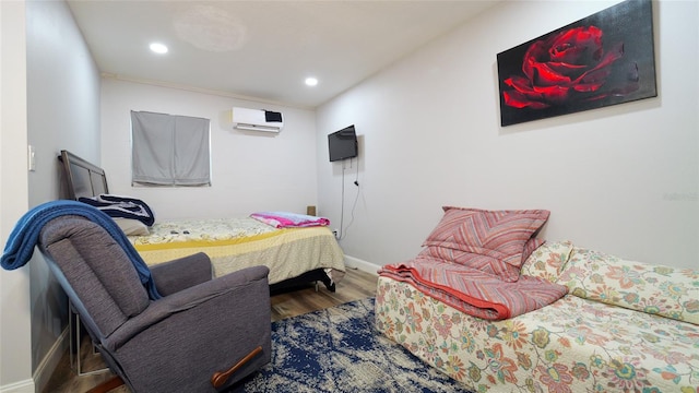 bedroom with a wall unit AC and hardwood / wood-style flooring