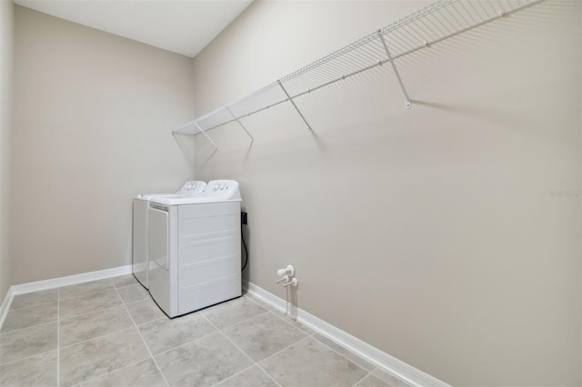 laundry area with light tile patterned floors and washer and clothes dryer