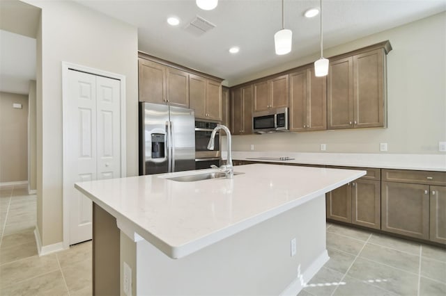 kitchen featuring light tile patterned flooring, sink, an island with sink, and stainless steel appliances