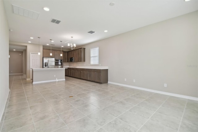 kitchen featuring a center island, decorative light fixtures, light tile patterned floors, a notable chandelier, and stainless steel appliances