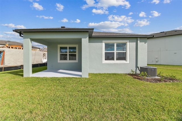 back of property featuring a lawn, cooling unit, and a patio