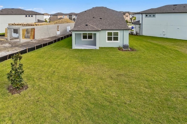 rear view of property featuring central AC, a patio area, and a lawn