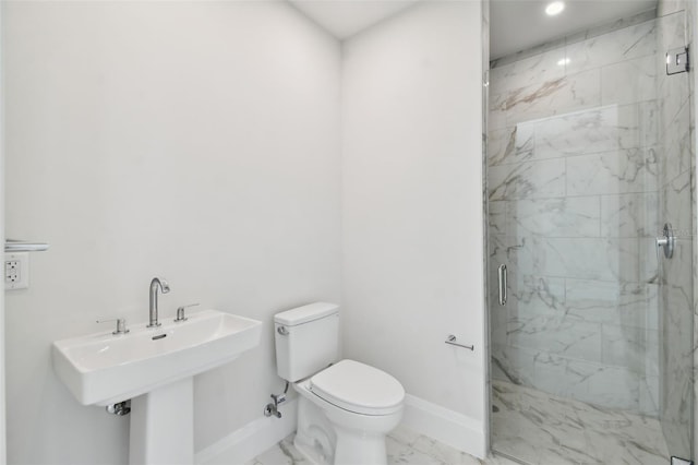 bathroom featuring toilet, a shower with shower door, and sink