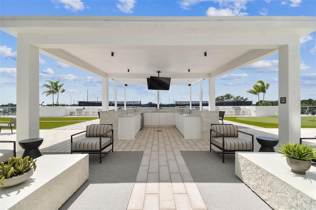 view of patio / terrace featuring a bar and exterior kitchen