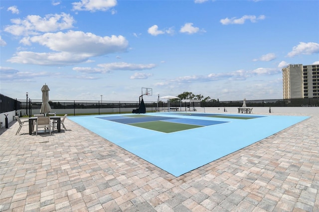 view of pool featuring basketball hoop and tennis court