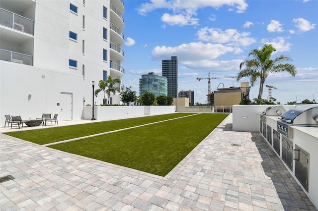 view of home's community featuring a lawn, a patio area, and exterior kitchen