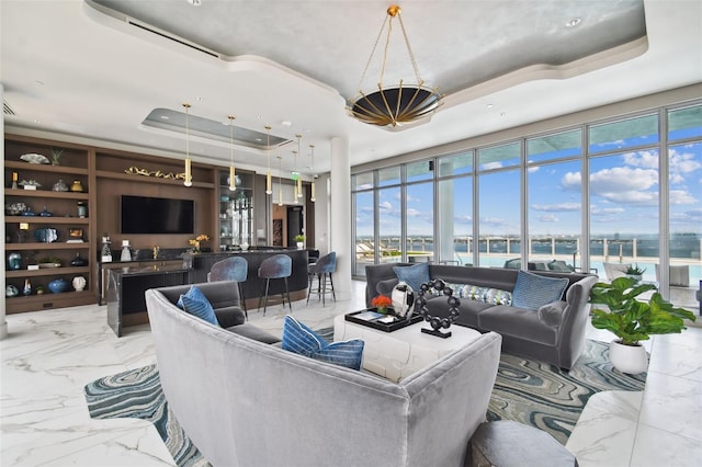 living room featuring built in shelves, floor to ceiling windows, a raised ceiling, and indoor bar