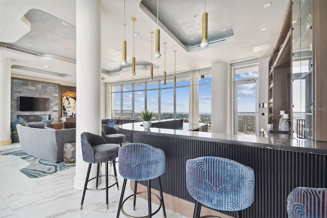 bar featuring a raised ceiling and a stone fireplace