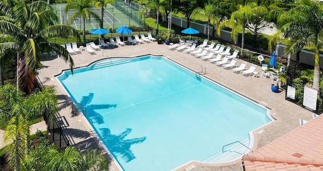 pool with a patio area and fence