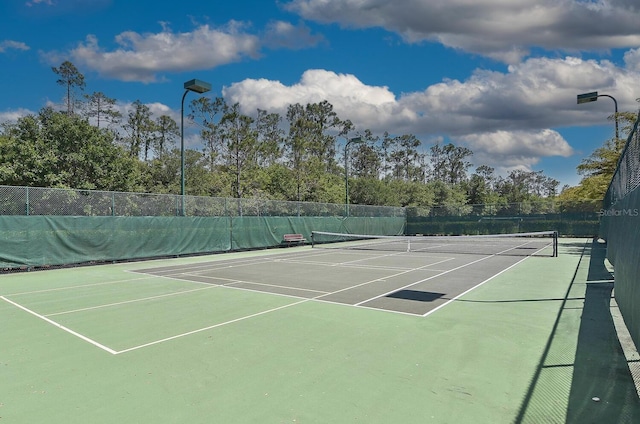 view of tennis court featuring fence