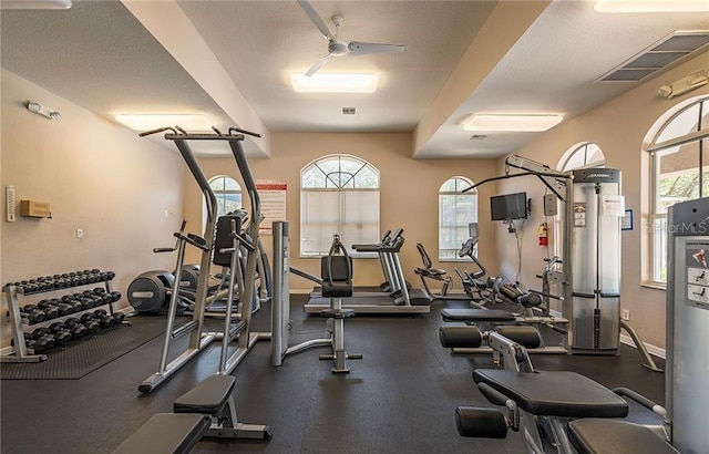 gym featuring baseboards, visible vents, and a ceiling fan