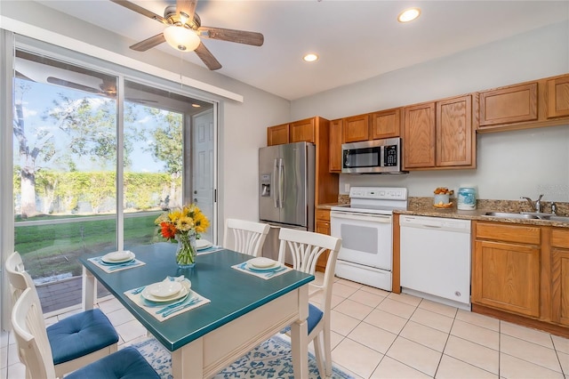 kitchen with brown cabinets, stainless steel appliances, a sink, and recessed lighting