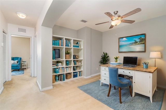 office with a ceiling fan, visible vents, light carpet, and baseboards