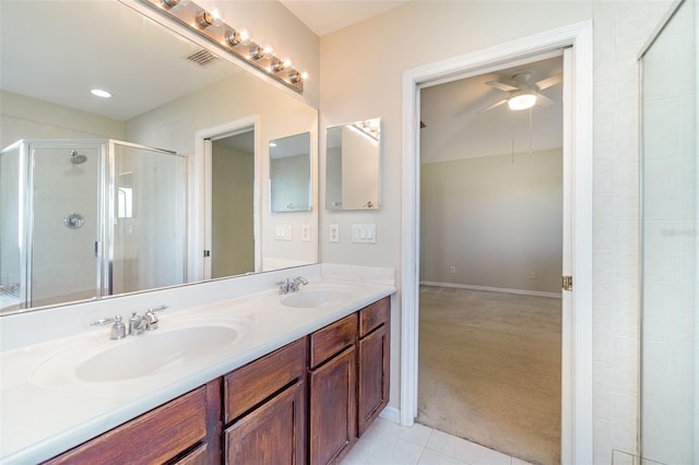 full bath with double vanity, a stall shower, a sink, and tile patterned floors