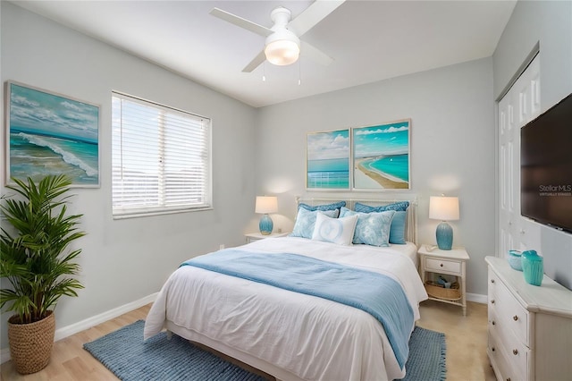 bedroom featuring a closet, light wood-type flooring, a ceiling fan, and baseboards