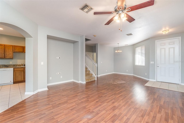 unfurnished living room with ceiling fan with notable chandelier and light wood-type flooring