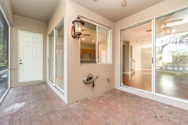 unfurnished sunroom featuring a ceiling fan