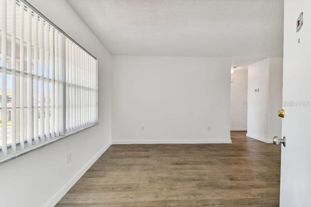 spare room with a textured ceiling and hardwood / wood-style floors