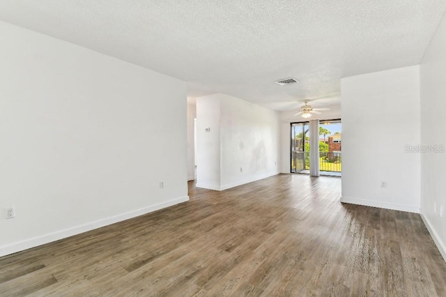 spare room featuring ceiling fan, a textured ceiling, and wood-type flooring