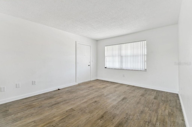 spare room featuring a textured ceiling and hardwood / wood-style flooring