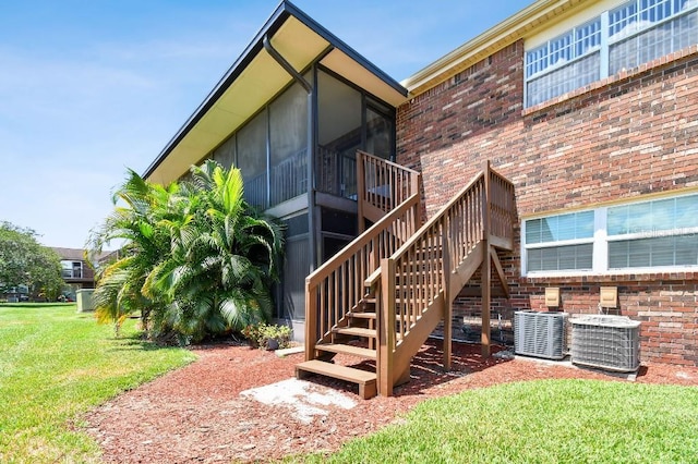 back of house featuring a sunroom, cooling unit, and a yard