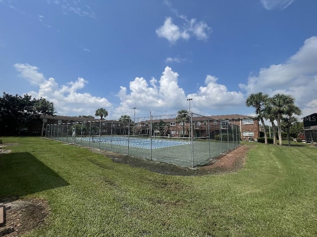 view of tennis court with a lawn