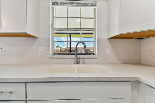 kitchen featuring white cabinets, sink, and decorative backsplash