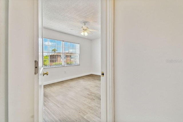 unfurnished room featuring ceiling fan, hardwood / wood-style flooring, and a textured ceiling