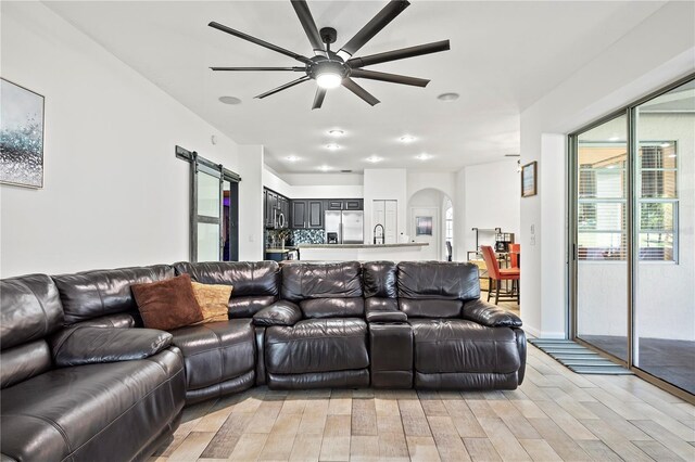 living room with ceiling fan, light hardwood / wood-style flooring, and sink