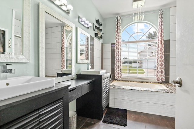 bathroom featuring double vanity, a notable chandelier, tile patterned floors, and tiled bath