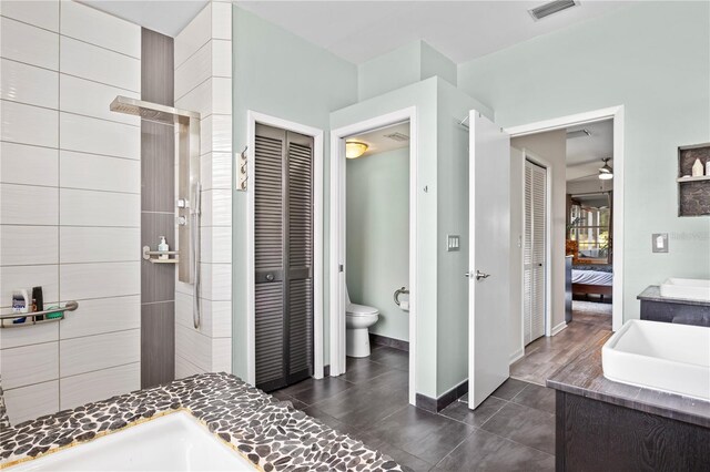 bathroom featuring ceiling fan, vanity, toilet, and tile patterned flooring