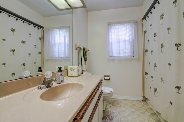 bathroom featuring a healthy amount of sunlight, toilet, and vanity