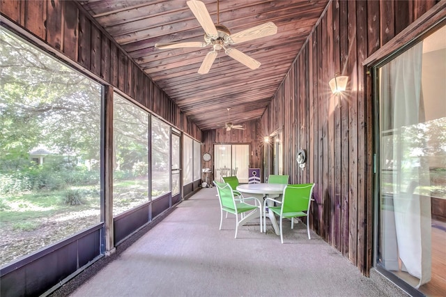 unfurnished sunroom with ceiling fan, wood ceiling, and vaulted ceiling