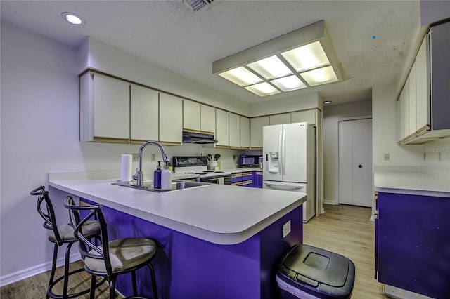 kitchen featuring light hardwood / wood-style flooring, white appliances, white cabinets, sink, and kitchen peninsula