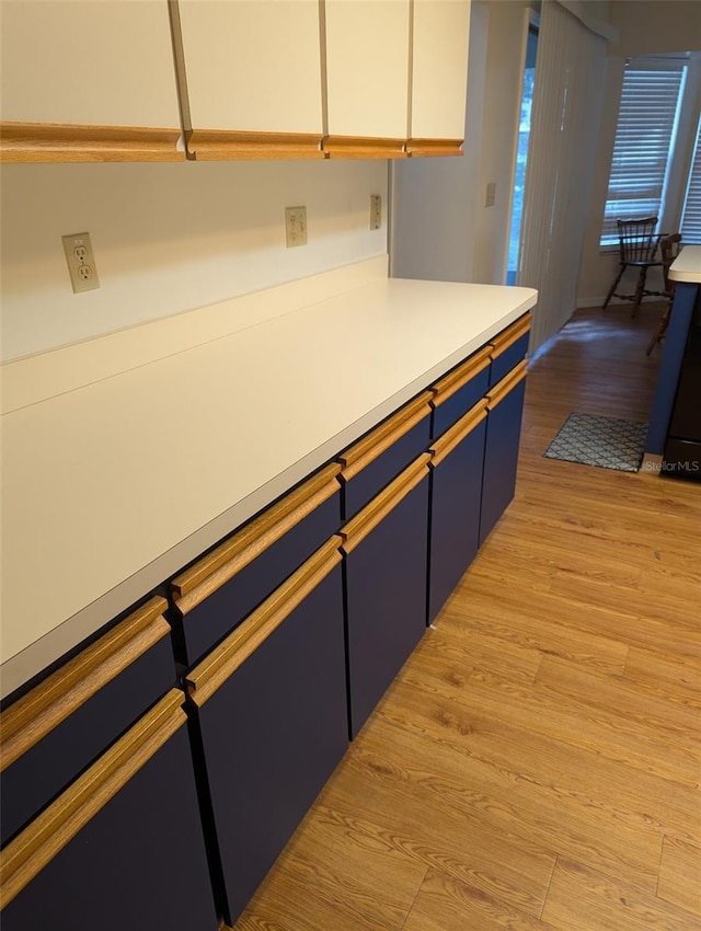 kitchen with white cabinetry and light hardwood / wood-style flooring