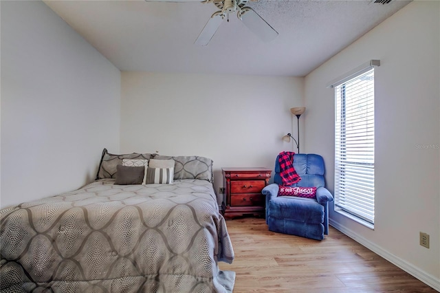 bedroom with multiple windows, light wood-type flooring, and ceiling fan