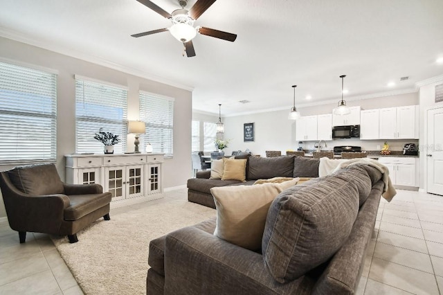 tiled living room with ceiling fan, sink, and crown molding